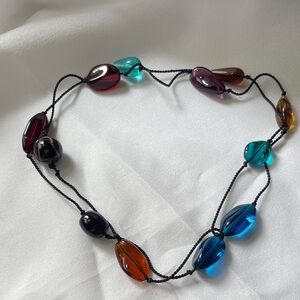 Glass beads necklace on a black cord.